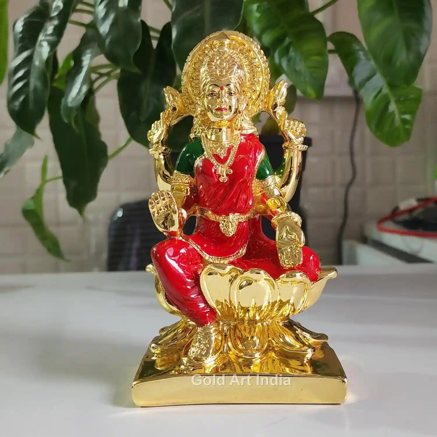 Front view of 7-inch Gold Plated Lakshmi Idol with Red Enamel dress and golden lotus base, handcrafted Hindu deity statue