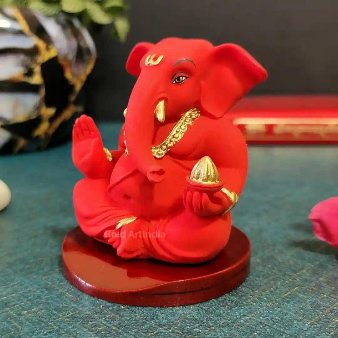 Elegant red and gold poly resin Ganesha idol on wooden base – side angled view