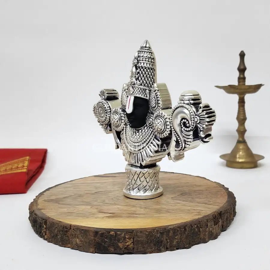 Antique Silver-finish Lord Balaji idol with black face placed on a wooden base.side view4.5 inch