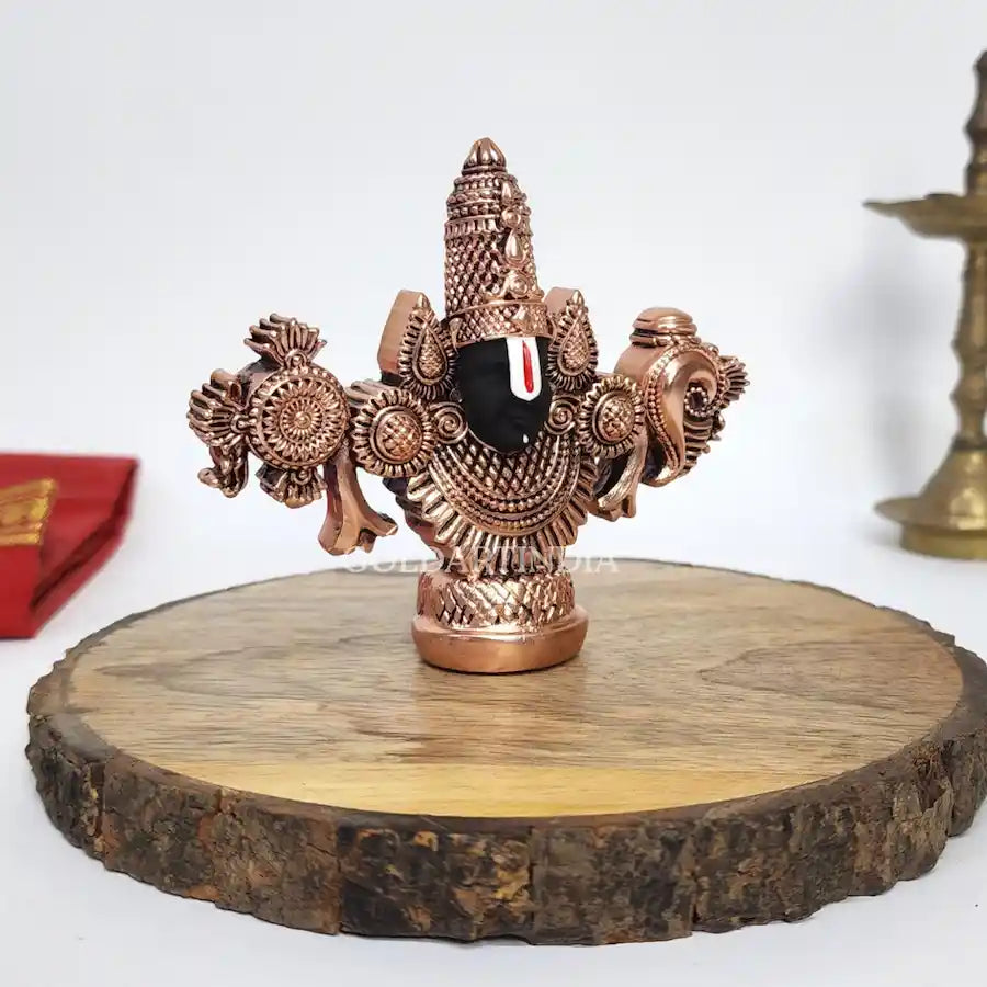 Antique copper-finish Lord Balaji idol with black face on wooden base. leftside