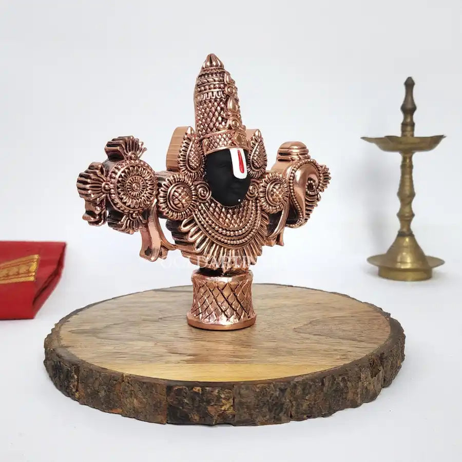 Antique copper-finish Lord Balaji idol with black face on wooden base. left side