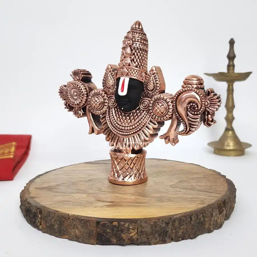 Antique copper-finish Lord Balaji idol with black face on wooden base. left side