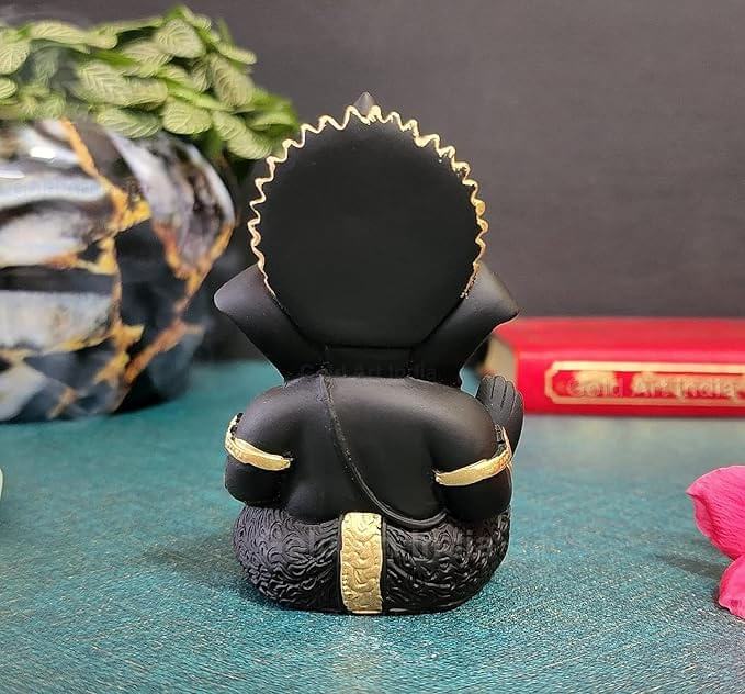 mango terracotta Ganesha idol with Gold detailing, seated in a blessing posture, holding a modak in one hand.