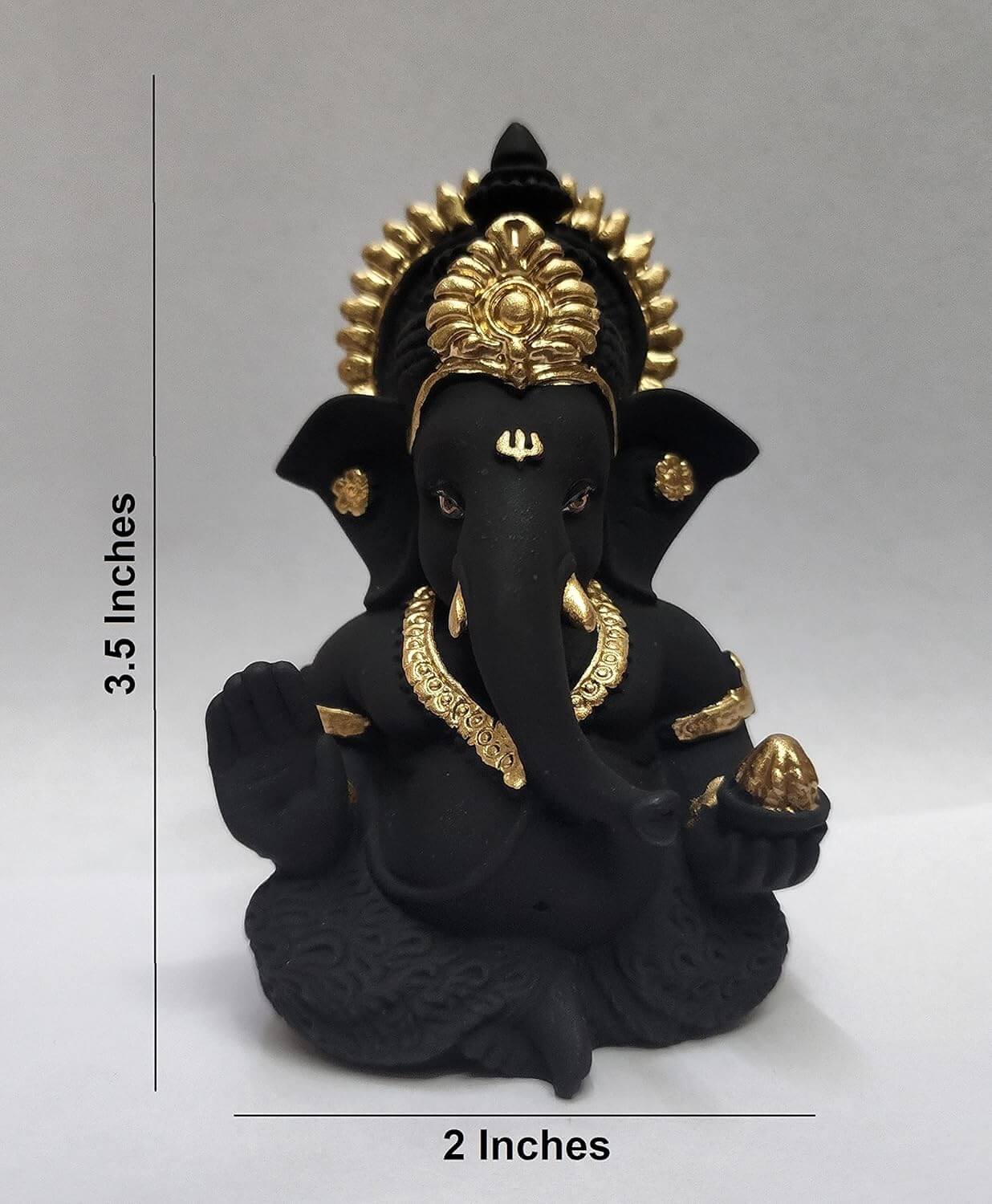 Black colour terracotta Ganesha idol with Gold detailing, seated in a blessing posture, holding a modak in one hand. dimension 3.5x2 inches