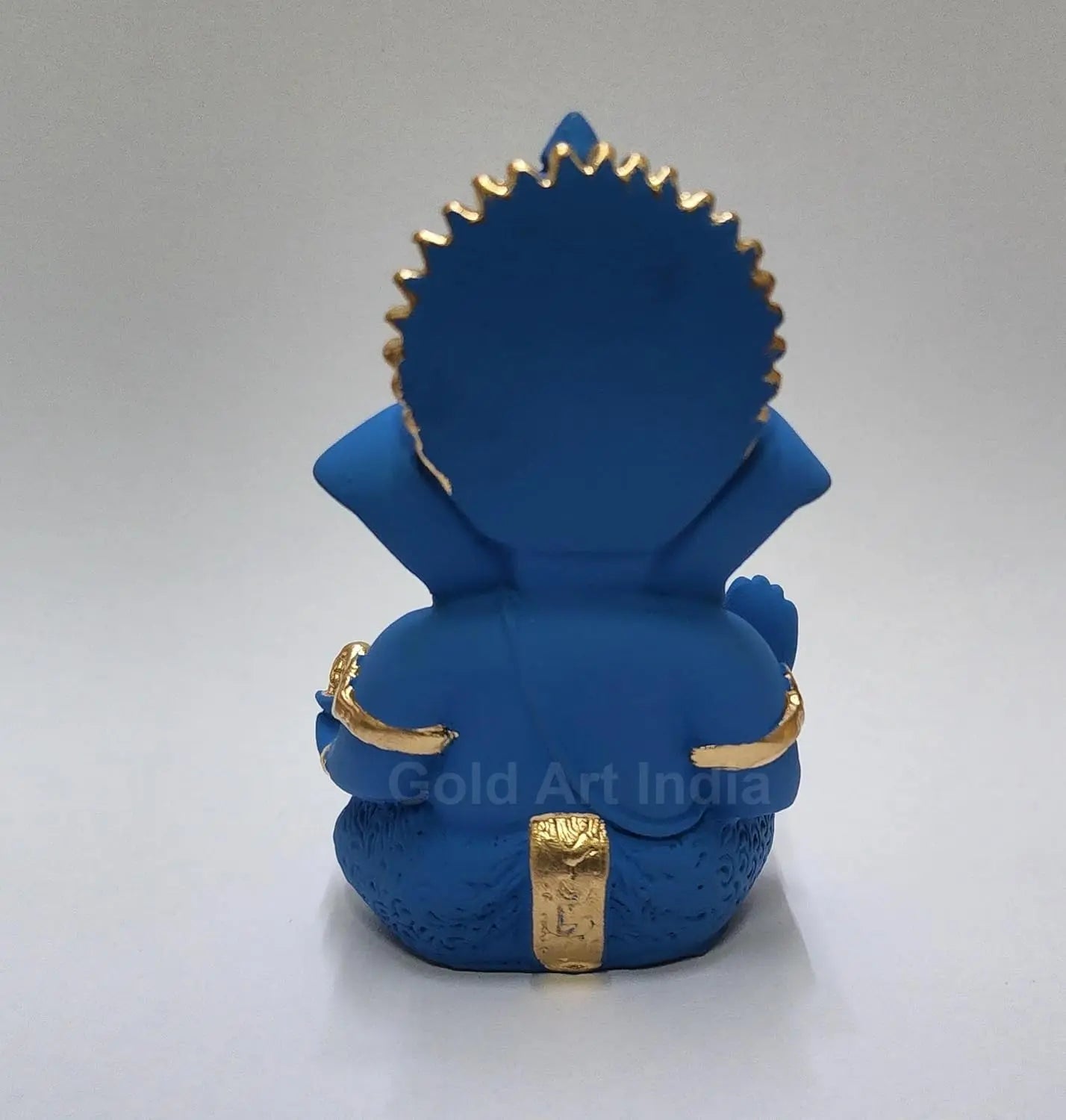 blue terracotta Ganesha idol with Gold detailing, seated in a blessing posture, holding a modak in one hand. back view