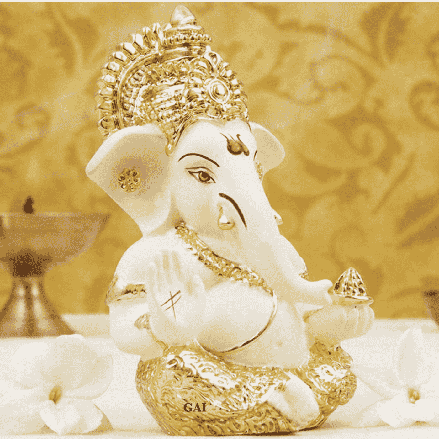 A Ceramic and gold Plated Lord Ganesha idol with an ornate golden crown, sitting in a blessing posture.