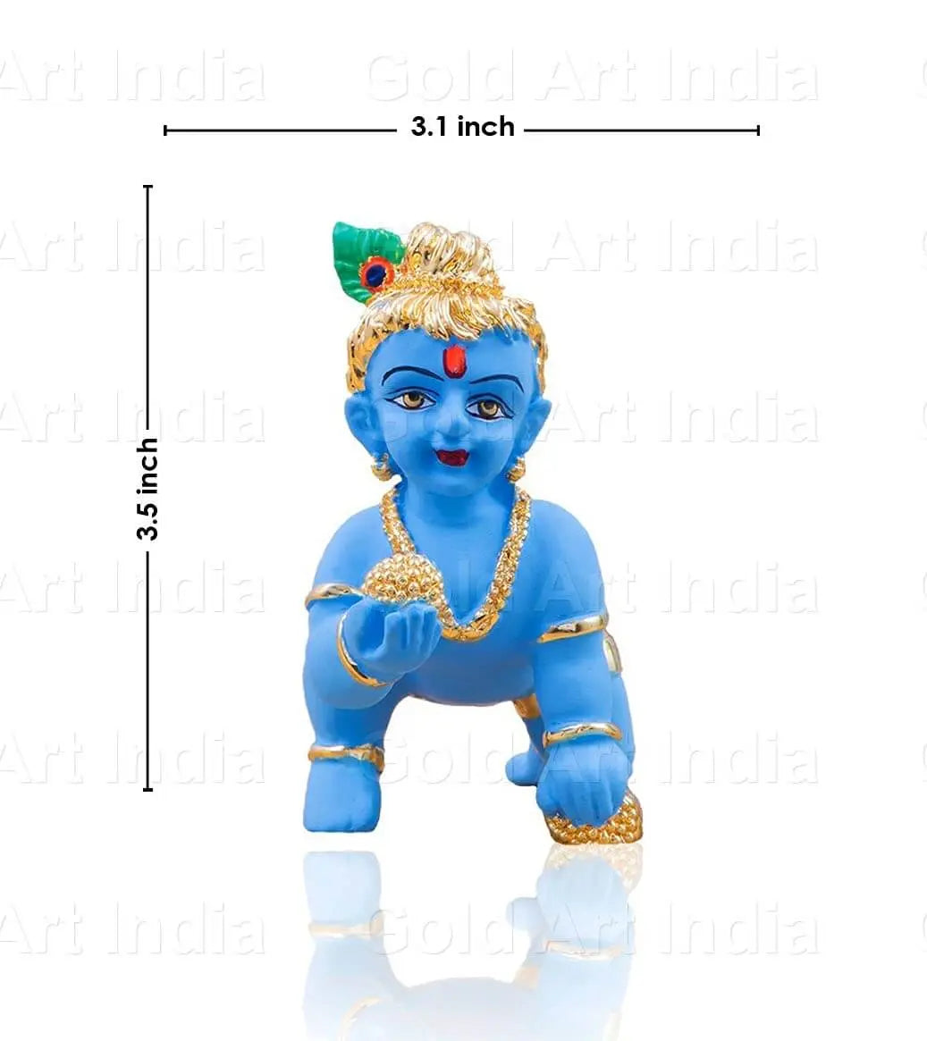 A 3.5-inch tall, 3.1-inch wide blue-colored Baby Krishna idol in a crawling pose, adorned with gold jewelry, a peacock feather on his head, and holding a golden laddu in his hand