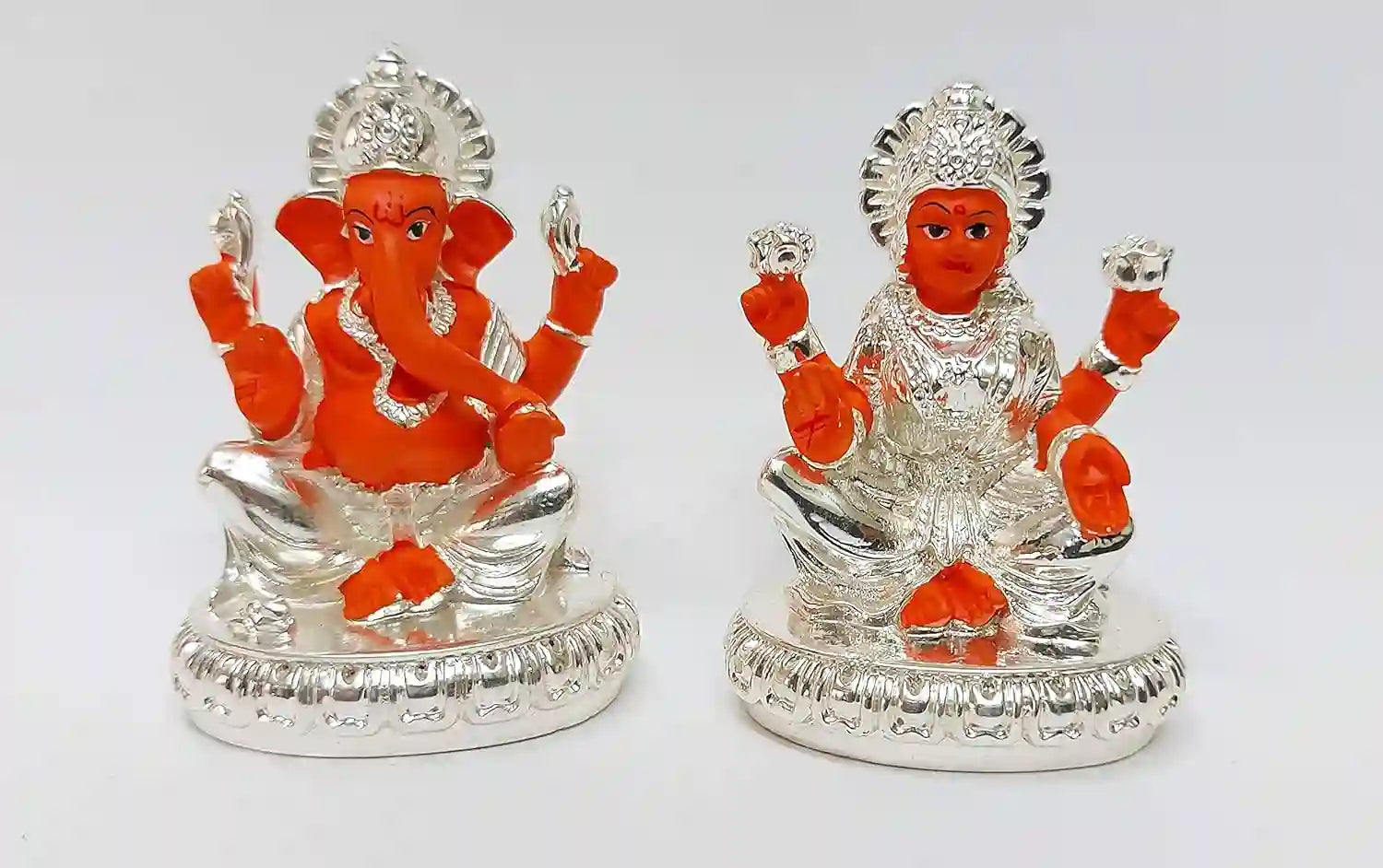 Front view of Lakshmi and Ganesha resin idol pair, crafted in premium resin with gold plating and silver-orange detailing, placed on decorative base
