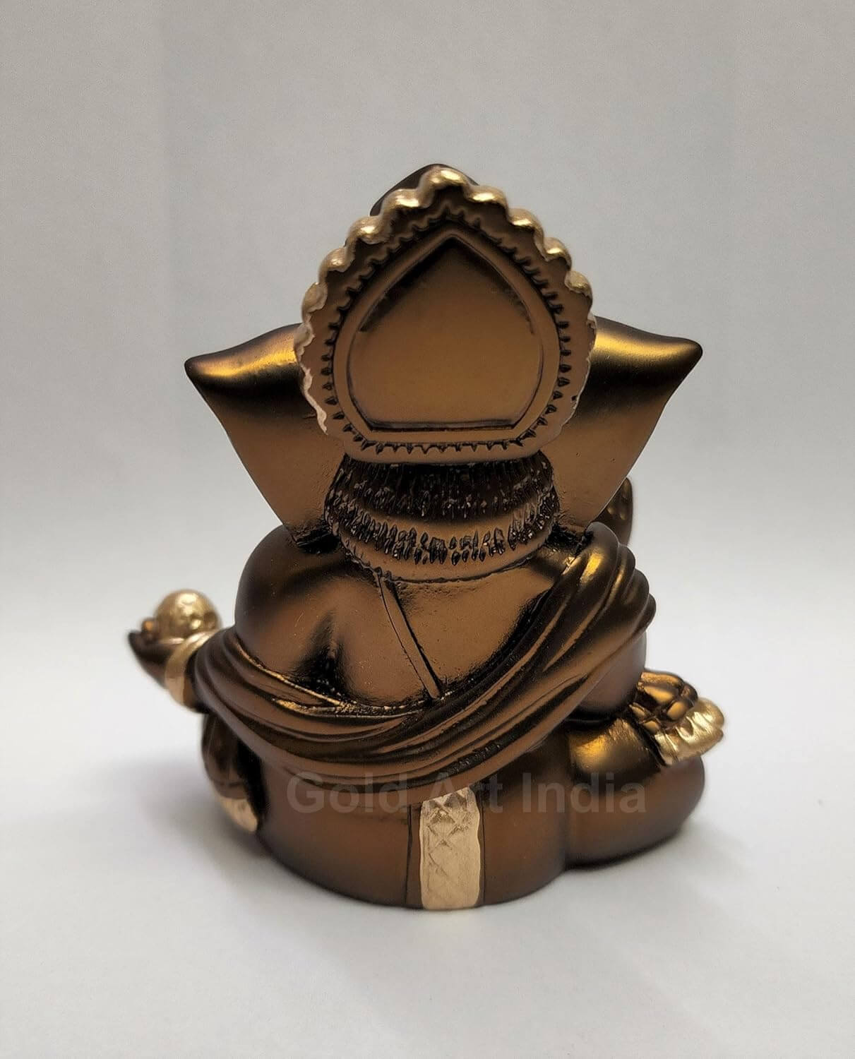 A 3.5-inch bronze-colored Ganesha statue with a crown, jewelry, and intricate carvings back view