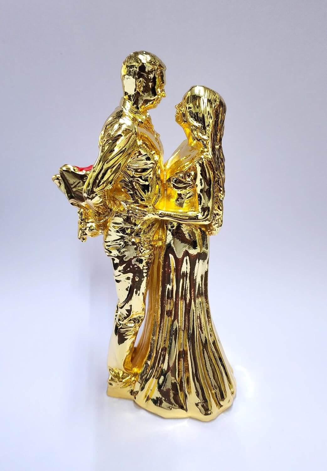 Gold-plated romantic couple figurine holding a Red rose bouquet.
