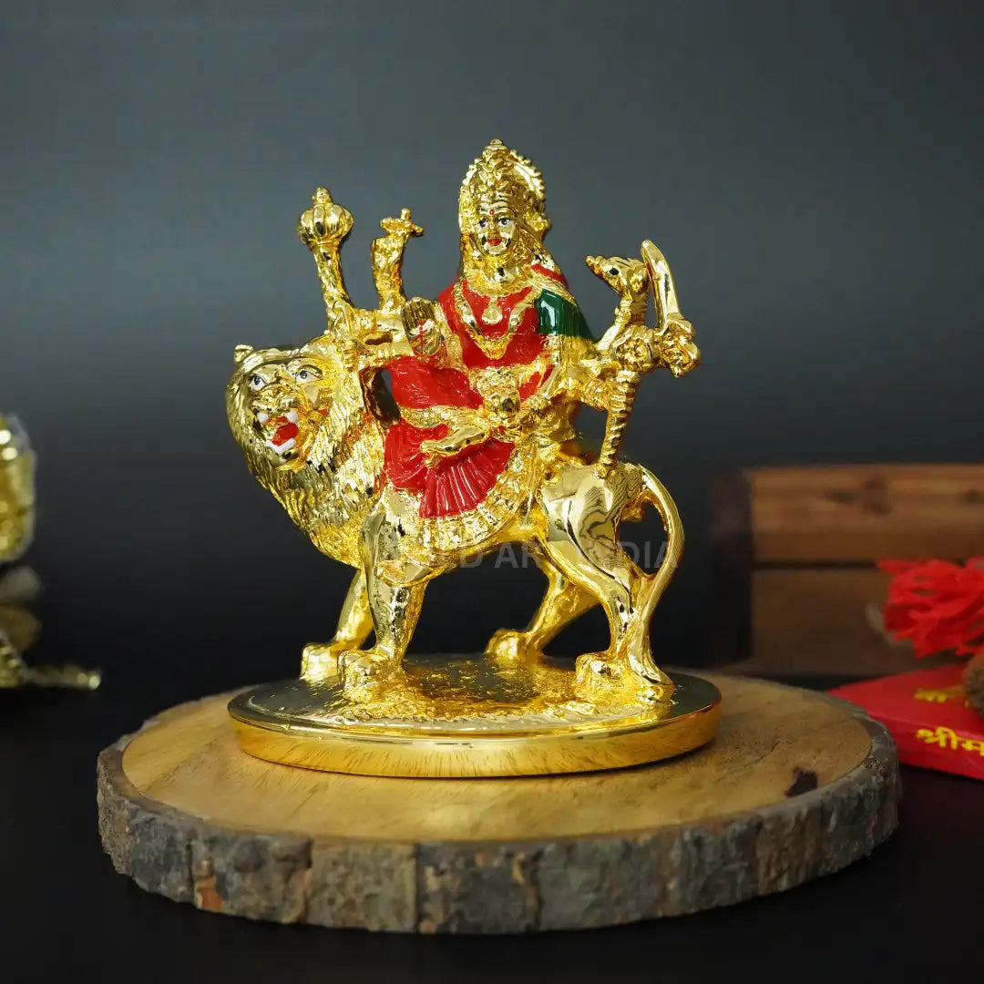 Front view of Gold Plated Maa Ambe
Idol riding lion with red enamel attire on wooden base