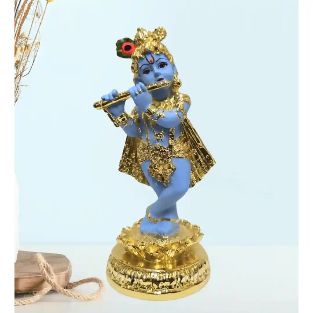 Gold-plated Krishna idol playing the flute, beautifully designed with a blue body and golden ornaments, standing on a decorative base