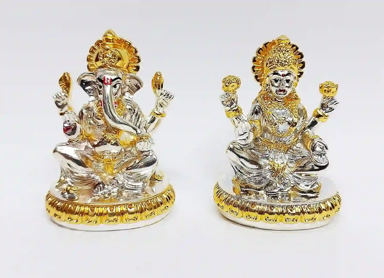 Handcrafted resin Lakshmi and Ganesha idol pair with gold & silver plating, seated on decorative pedestal, compact design for home & office décor.