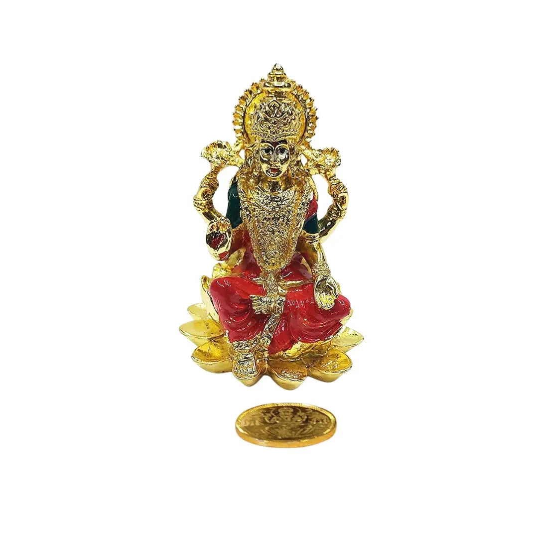 Gold plated Lakshmi idol with vibrant orange enamel finish, seated on lotus with gold-plated coin symbolizing prosperity.