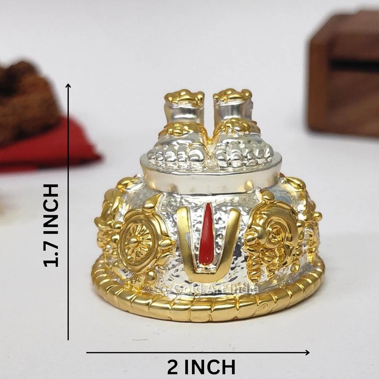 A silver and gold decorative idol featuring Lord Balaji's feet (Paduka) with intricate carvings of religious symbols and ornaments.
