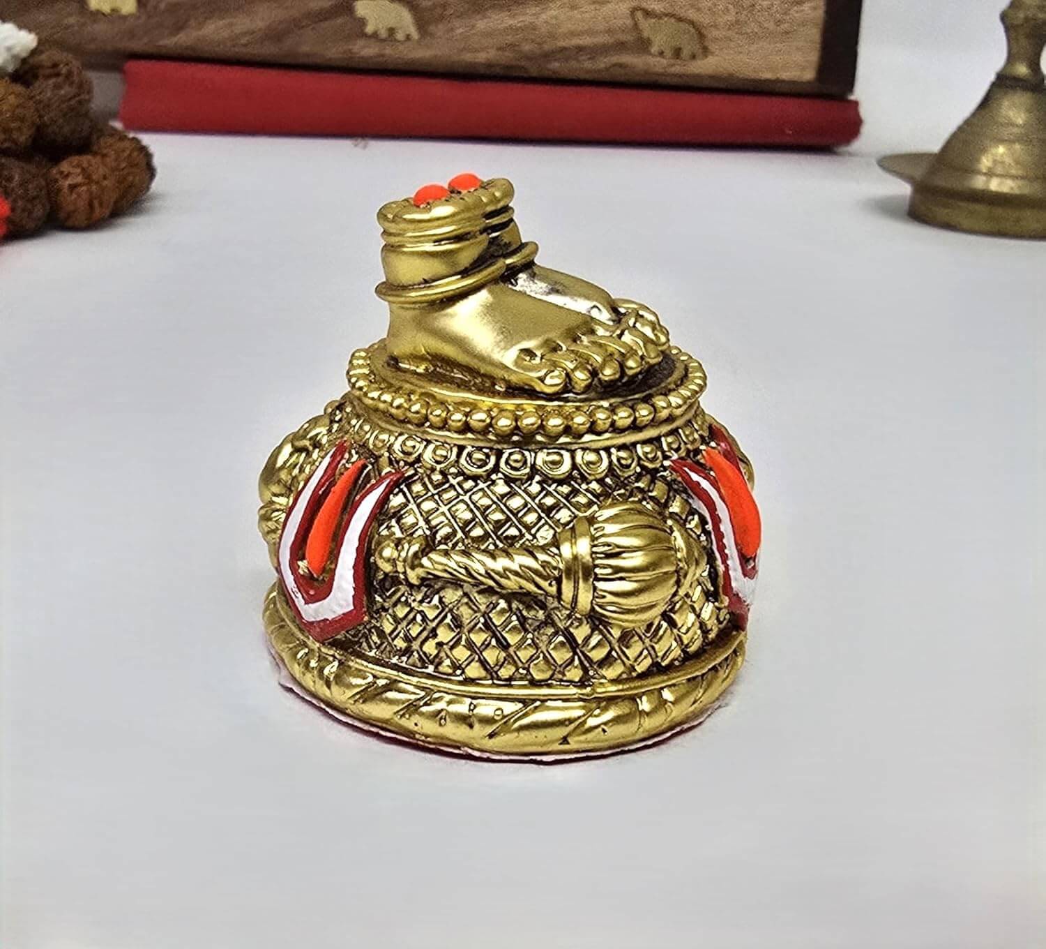 Gold-plated Hanuman Ji Charan Paduka idol placed on red cloth with detailed antique finish