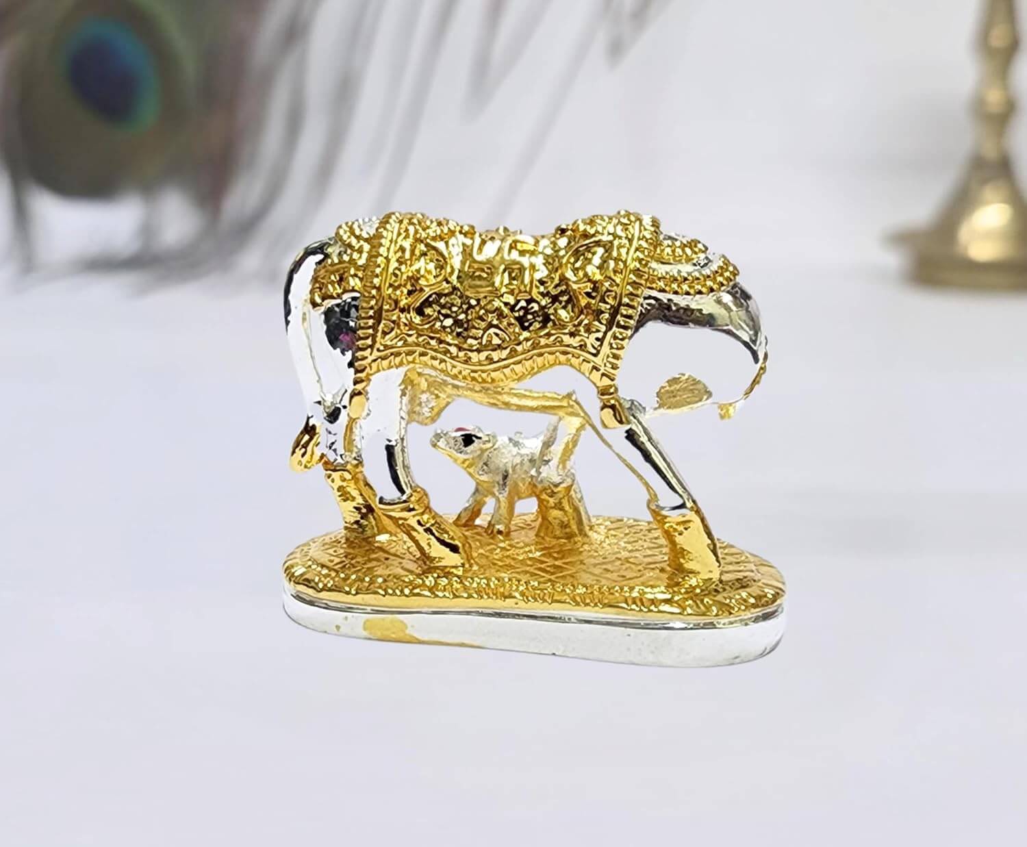 Gold Art India elegant silver and gold
Plated Kamadhenu cow and calf idol with intricate detailing, symbolizing prosperity and spiritual blessings. Perfect for home decor, puja rituals, and gifting