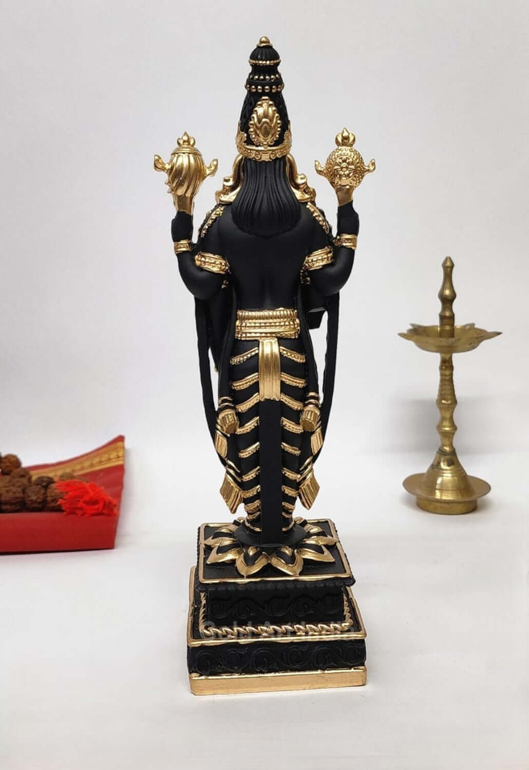 Black and gold Plated Lord Venkateshwara idol, intricately detailed with ornate jewelry and traditional symbols, standing on a decorated pedestal.
