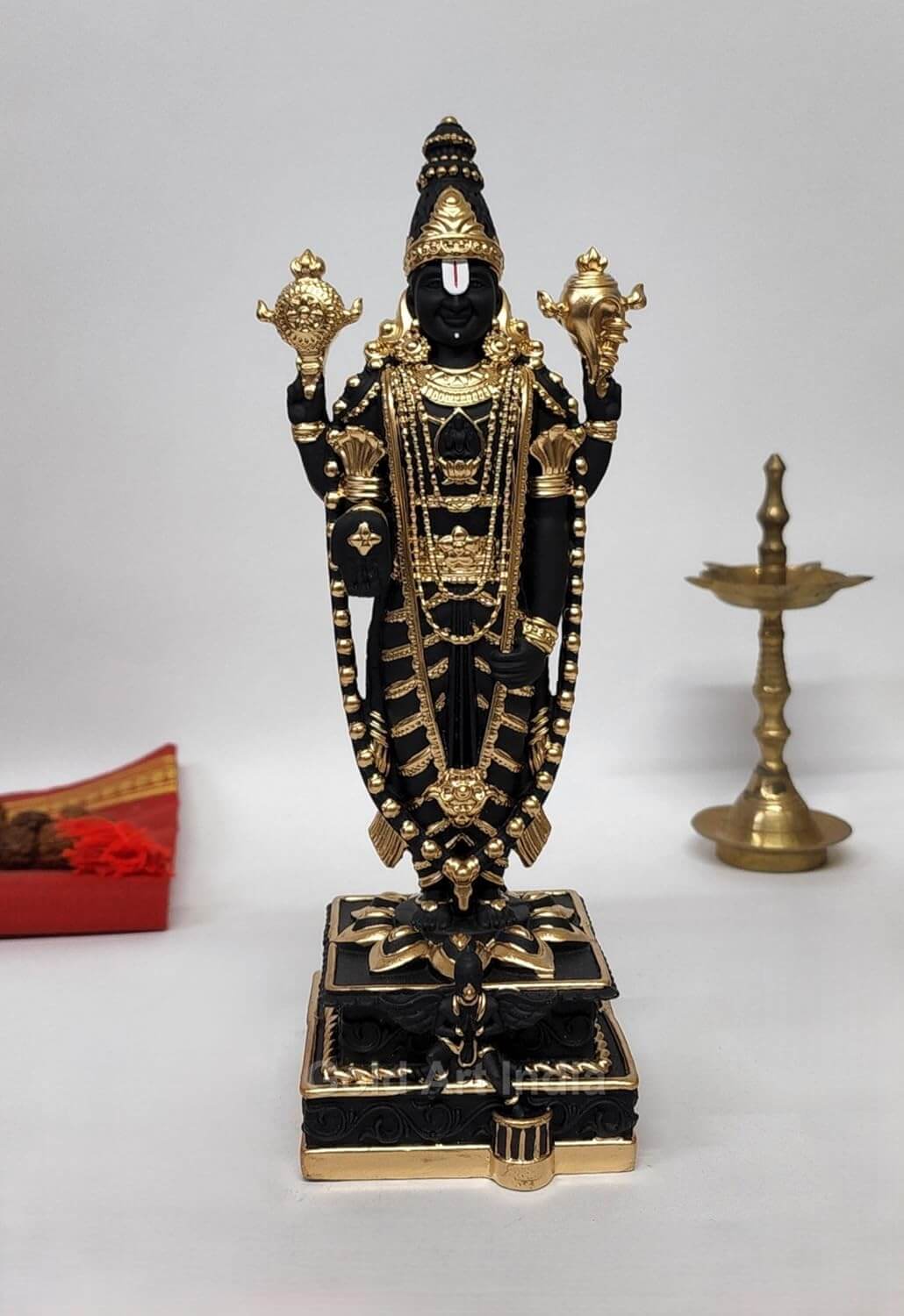 Black and gold Plated Lord Venkateshwara idol, intricately detailed with ornate jewelry and traditional symbols, standing on a decorated pedestal.
