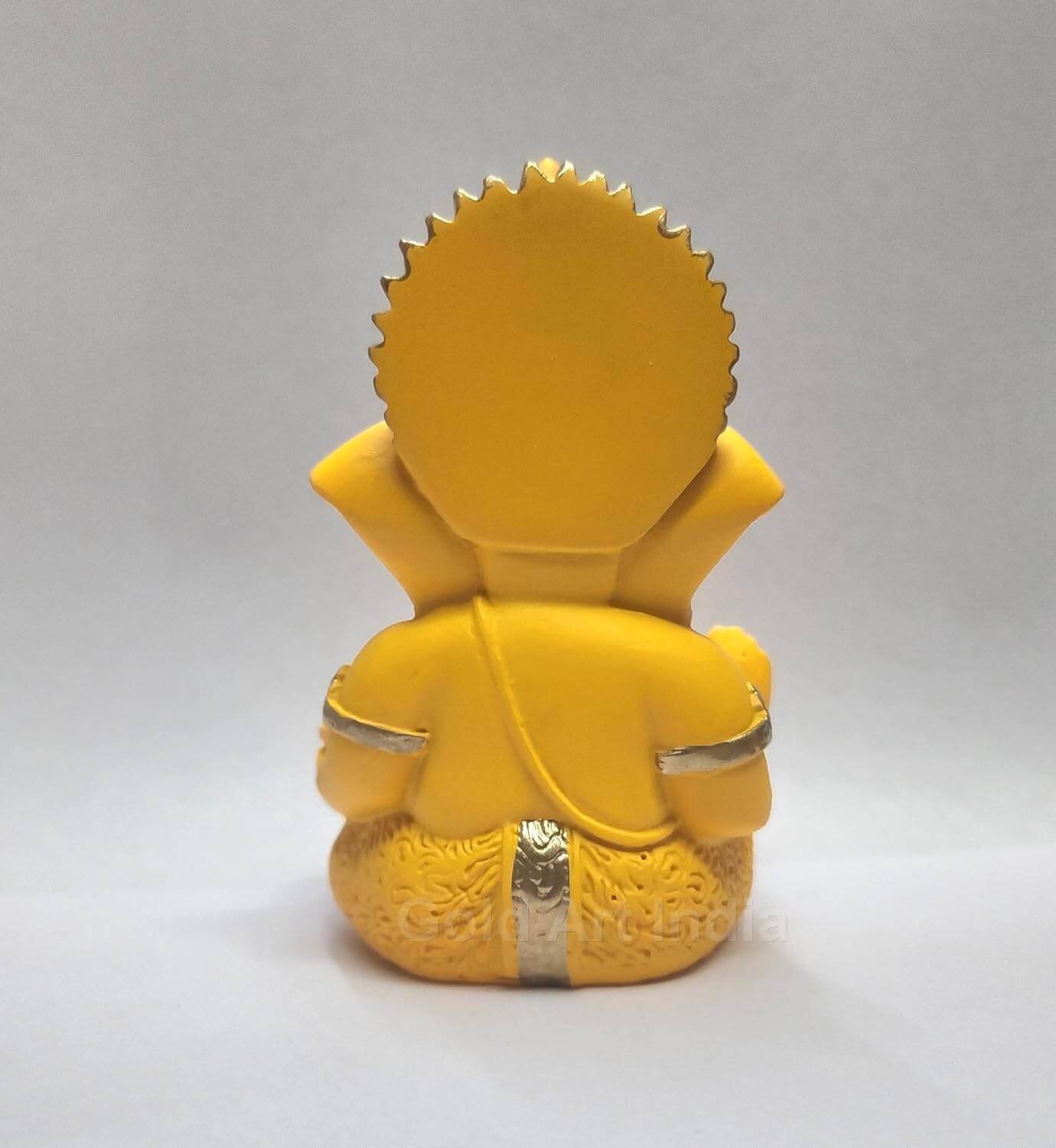 mango terracotta Ganesha idol with Gold detailing, seated in a blessing posture, holding a modak in one hand. back view
