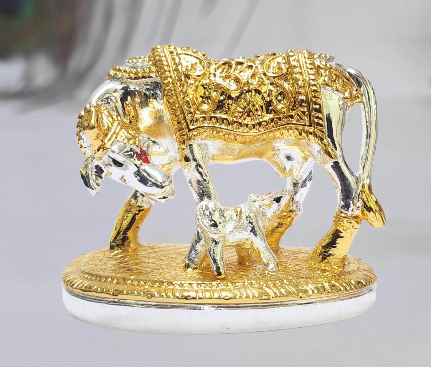Gold Art India elegant silver and gold
Plated Kamadhenu cow and calf idol with intricate detailing, symbolizing prosperity and spiritual blessings. Perfect for home decor, puja rituals, and gifting
