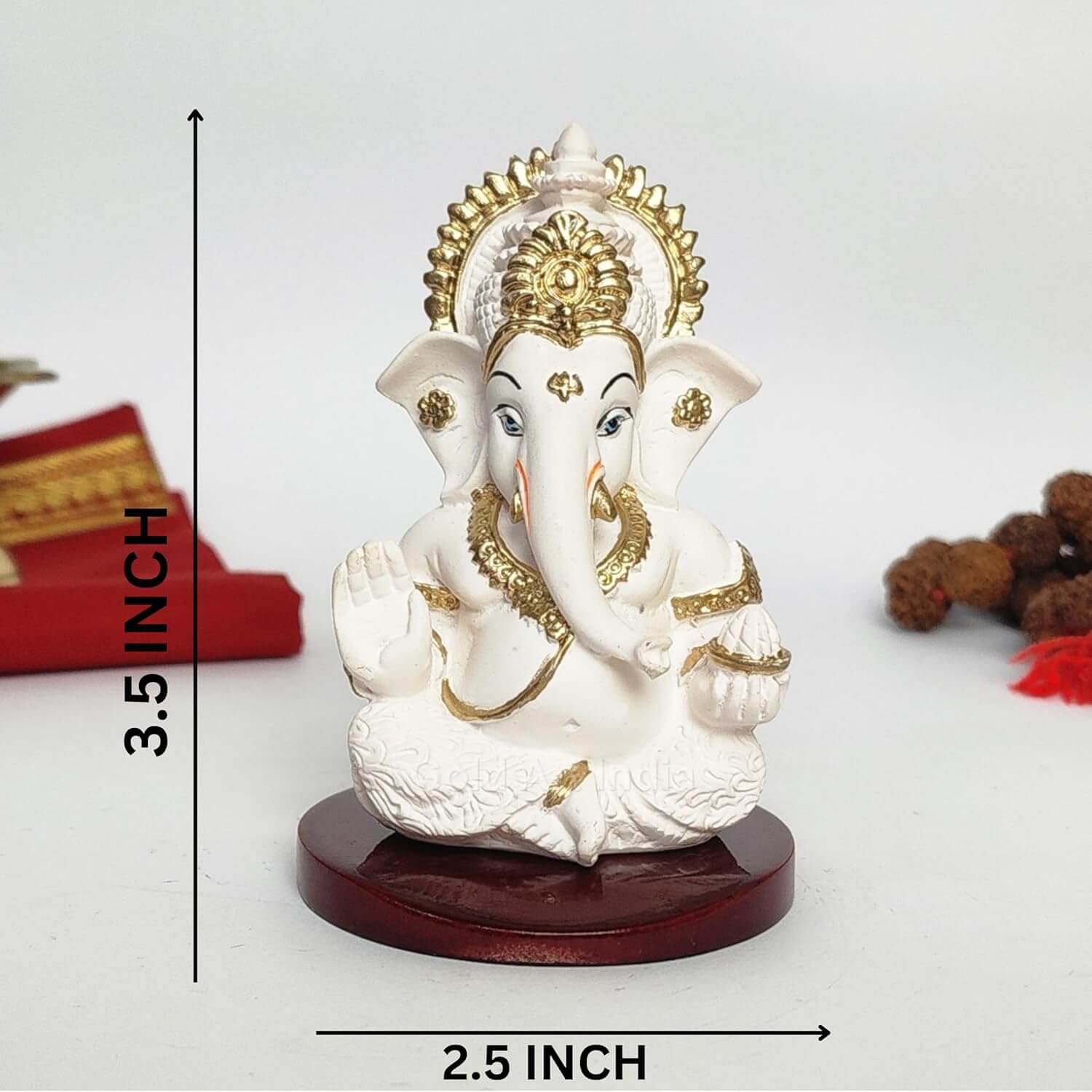 A 3.5-inch Peach Ivory Mdf base Ganesha statue with a crown, jewelry, and intricate carvings. One hand gives blessings, the other holds a modak. Decorated with Rudraksh and red cloth in the background.