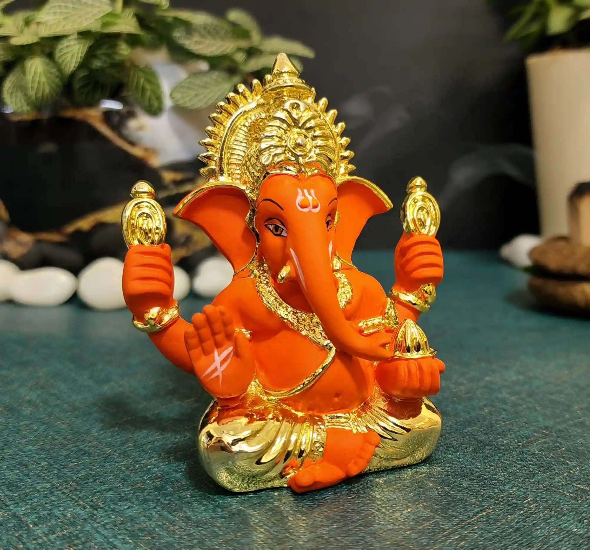 Side view of Orange Ganesh Idol on golden base – perfect for car dashboards, home temples, and festival gifting.
