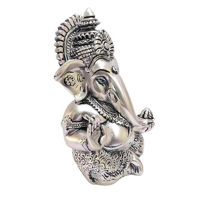 Silver Antique matte Ganesha idol with detailing, seated in a blessing posture, holding a modak in one hand.