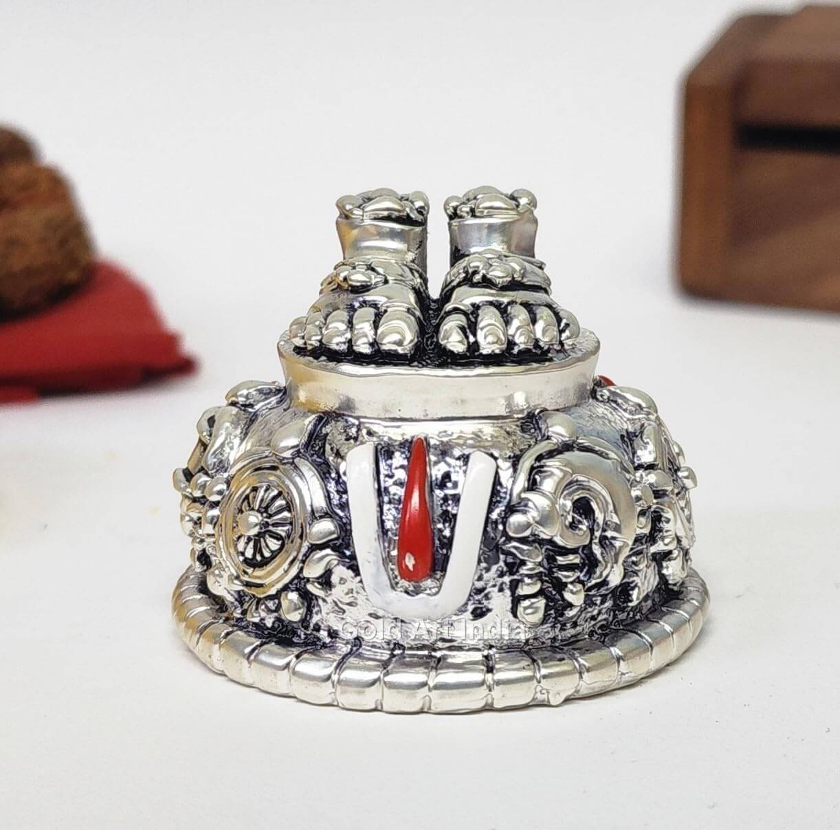 A silver Plated decorative idol featuring Lord Balaji's feet (Paduka) with intricate carvings of religious symbols and ornaments.