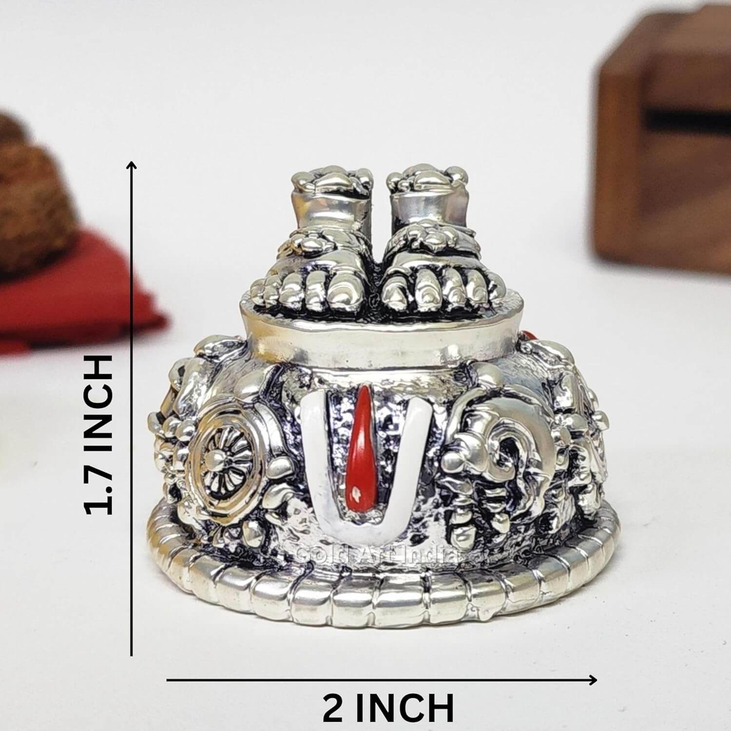 A silver Plated decorative idol featuring Lord Balaji's feet (Paduka) with intricate carvings of religious symbols and ornaments. size 2x1.7 inch