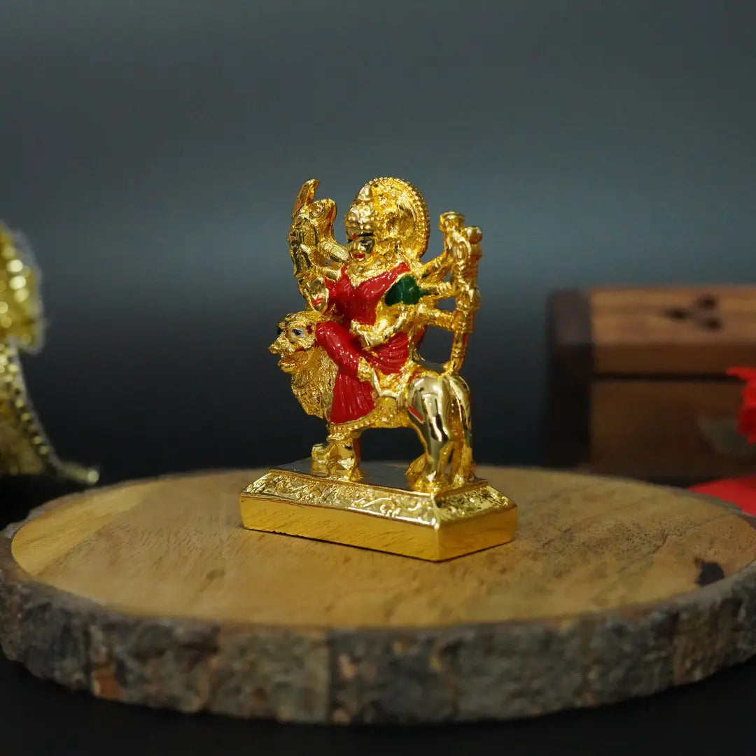 Side angle of 2.7-inch Gold Plated Ambe Maa Idol riding lion with multicolour attire, placed on wooden base | Gold Art India