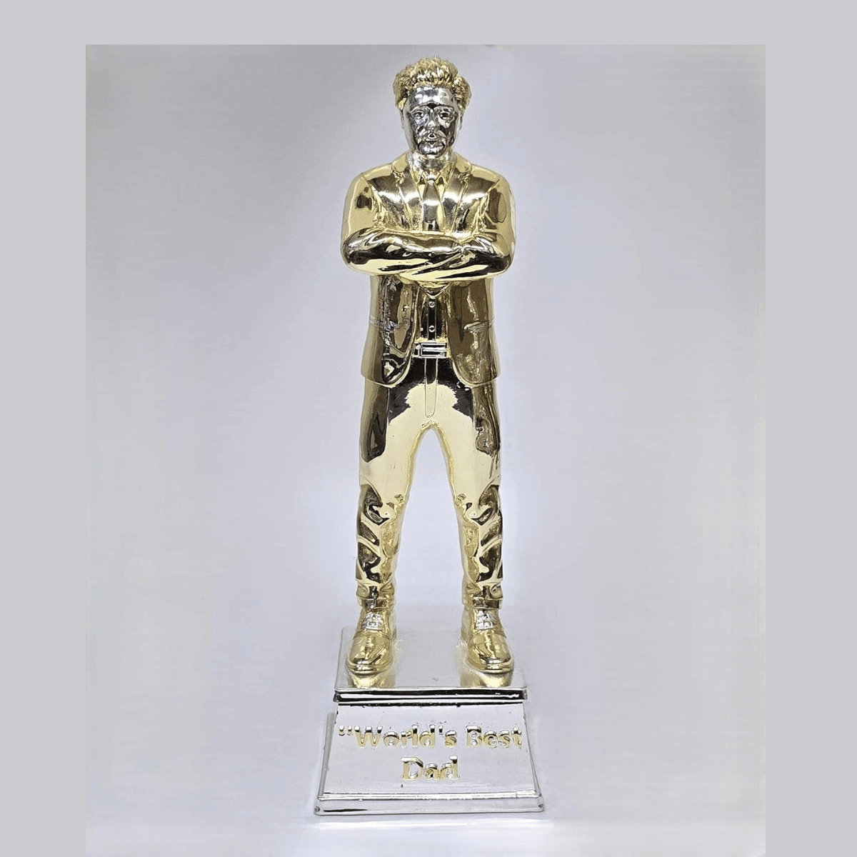 "Gold and silver-plated 'World's Best Dad' figurine, standing 9 inches tall with a 3-inch wide base, featuring a stylish man in a suit with crossed arms, ideal as a Father's Day or birthday gift."