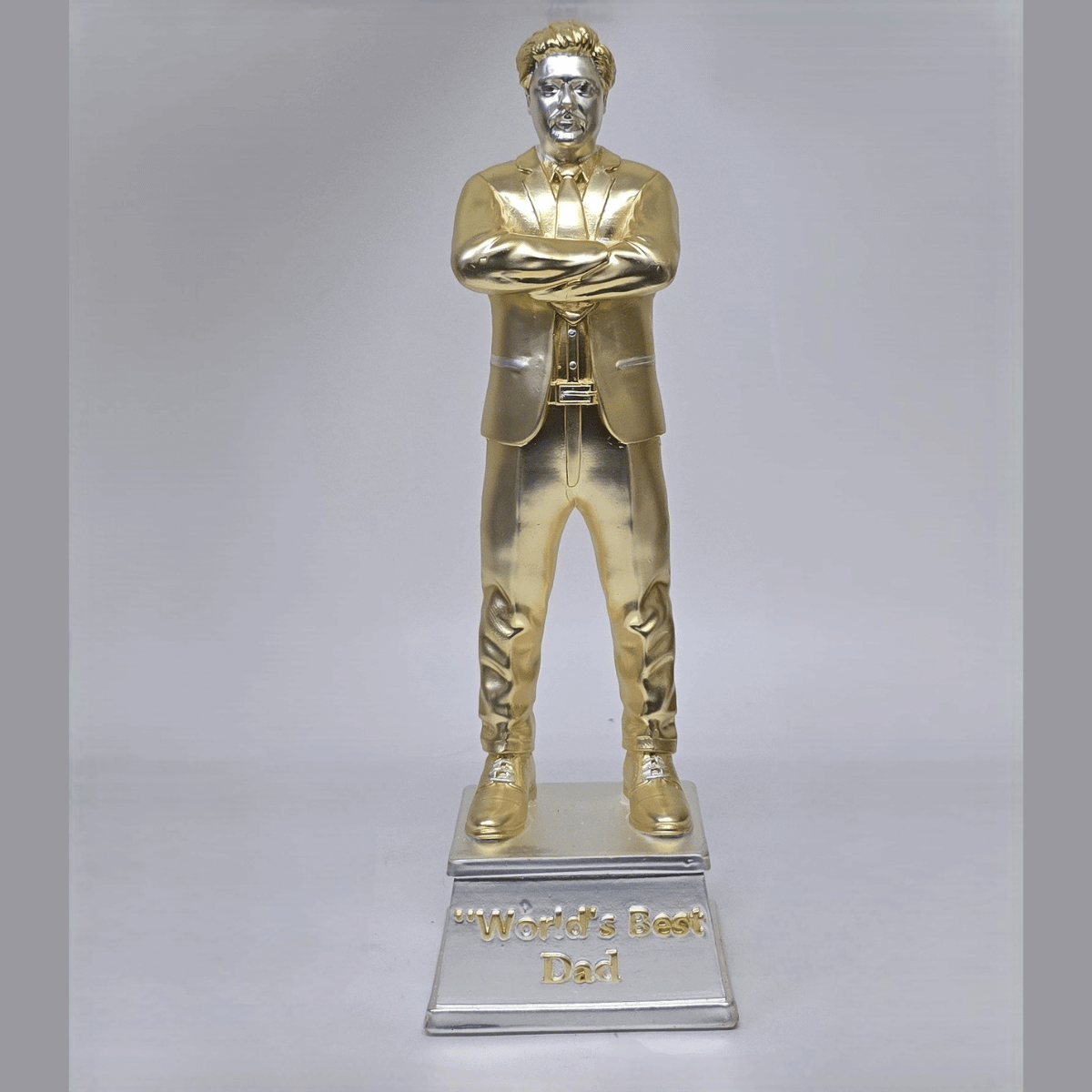 "Gold and silver-plated 'World's Best Dad' figurine, standing 9 inches tall with a 3-inch wide base, featuring a stylish man in a suit with crossed arms, ideal as a Father's Day or birthday gift."