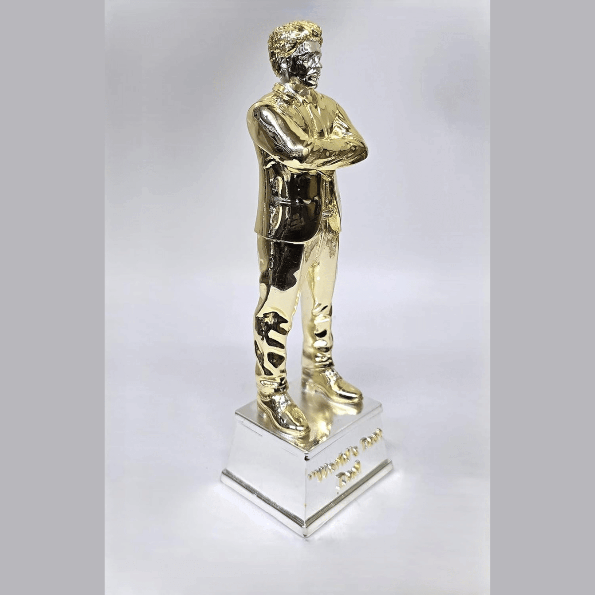 "Gold and silver-plated 'World's Best Dad' figurine, standing 9 inches tall with a 3-inch wide base, featuring a stylish man in a suit with crossed arms, ideal as a Father's Day or birthday gift."