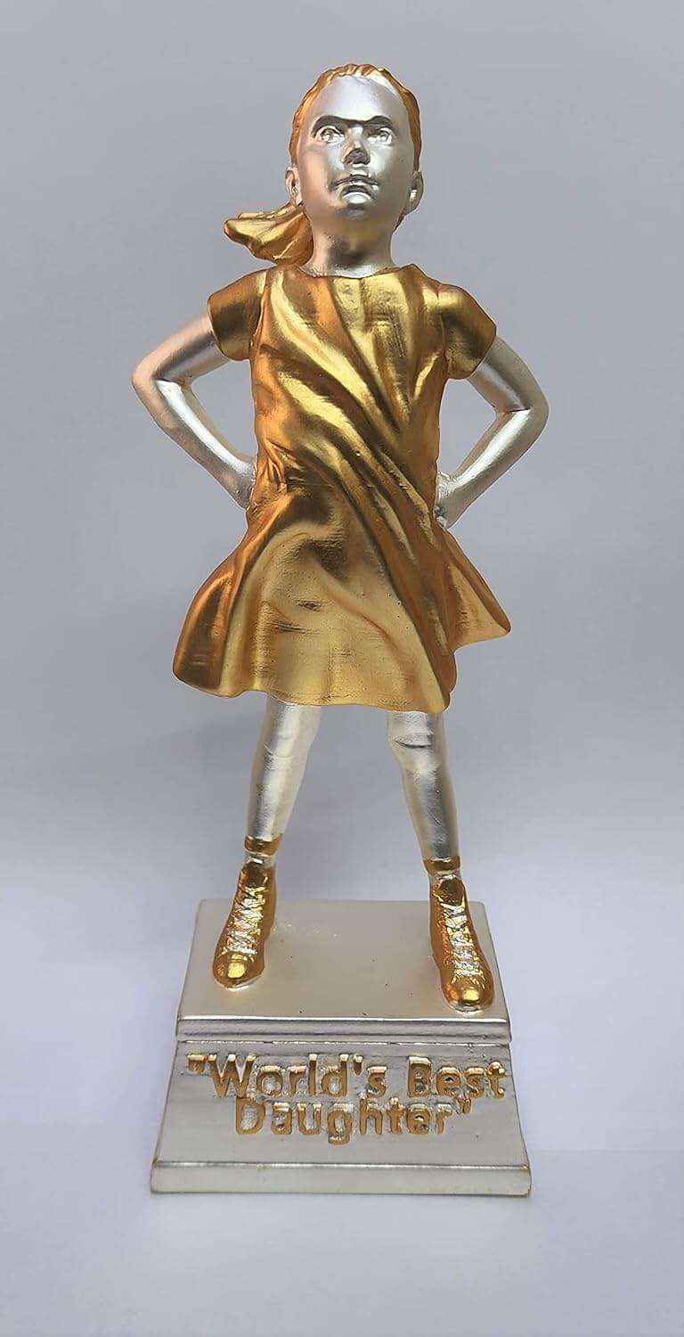 A gold and silver Plated trophy of a confident young girl standing with her hands on her hips. The trophy has a gold dress and shoes, while the rest of the figure is silver. It stands on a silver base with the engraved text "World's Best Daughter.