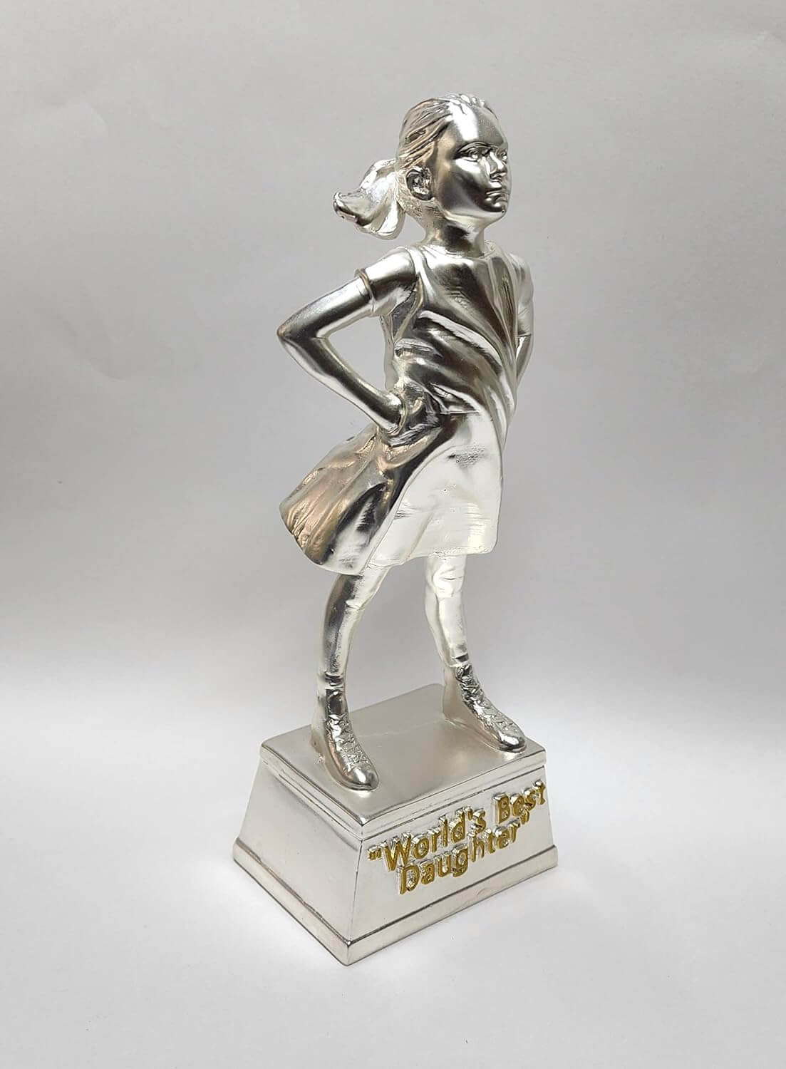 A silver-plated trophy of a confident young girl standing with her hands on her hips. The figure is fully silver, with a flowing dress and ponytail. The trophy stands on a rectangular silver base with the engraved text "World's Best Daughter" . The dimensions of the trophy are marked as 8 inches in height and 3 inches in width.