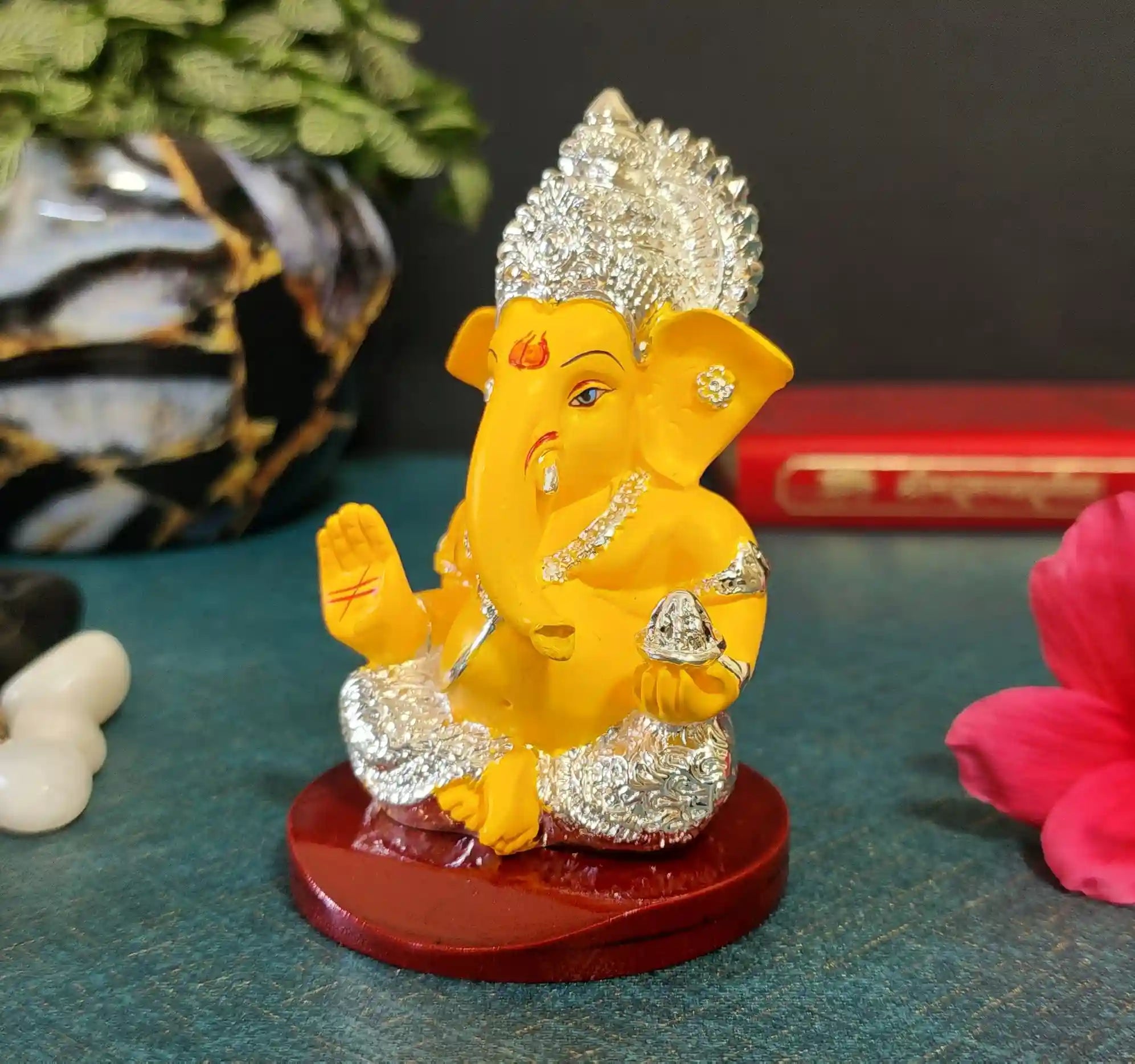 Yellow and silver plated Ganesha Idol placed on MDF wooden base for stability.