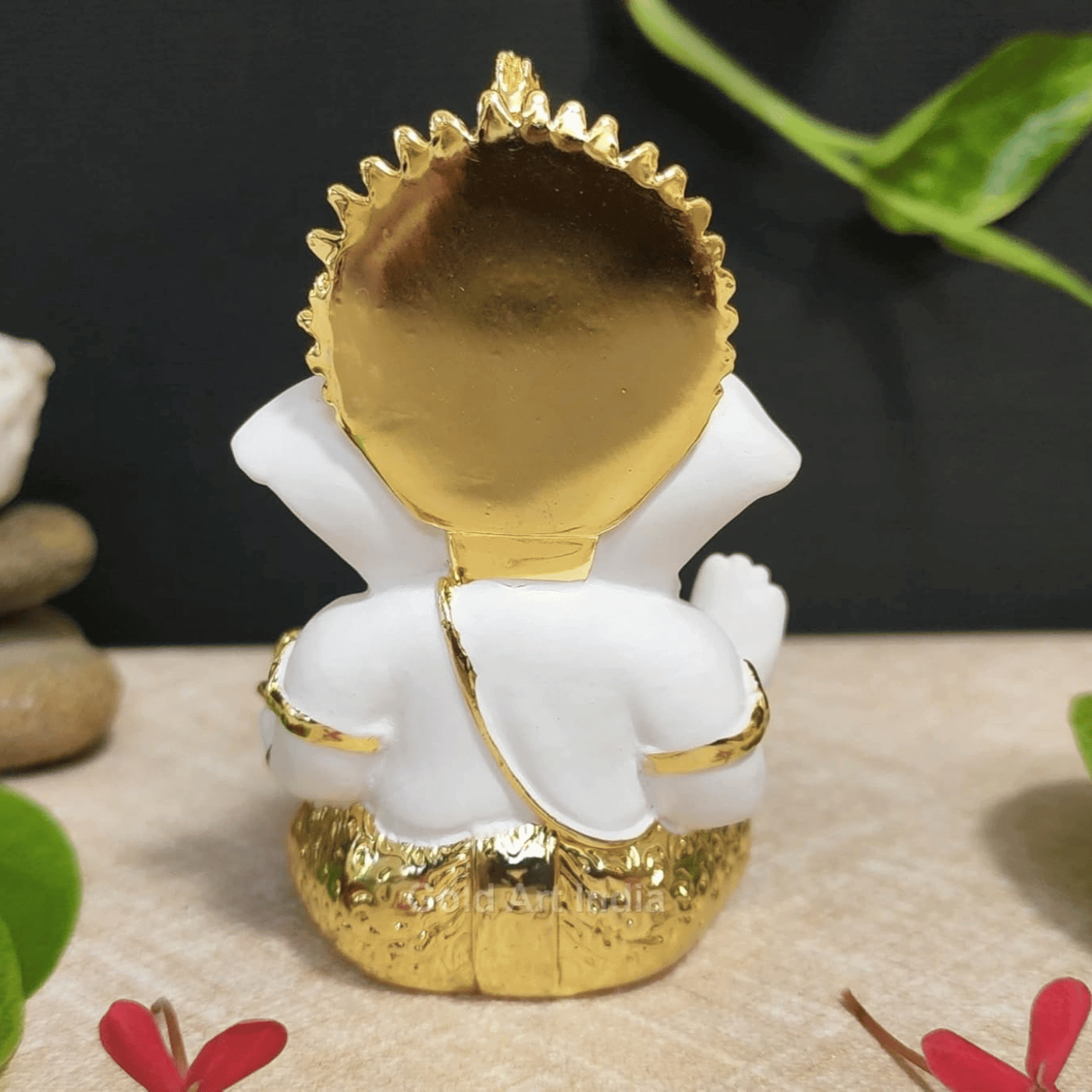 Back view of a white and gold Lord Ganesha idol with intricate detailing.