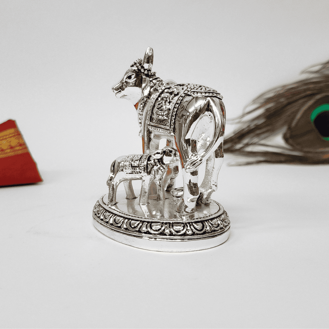 Close-up of Kamdhenu Cow and Calf idol on white background