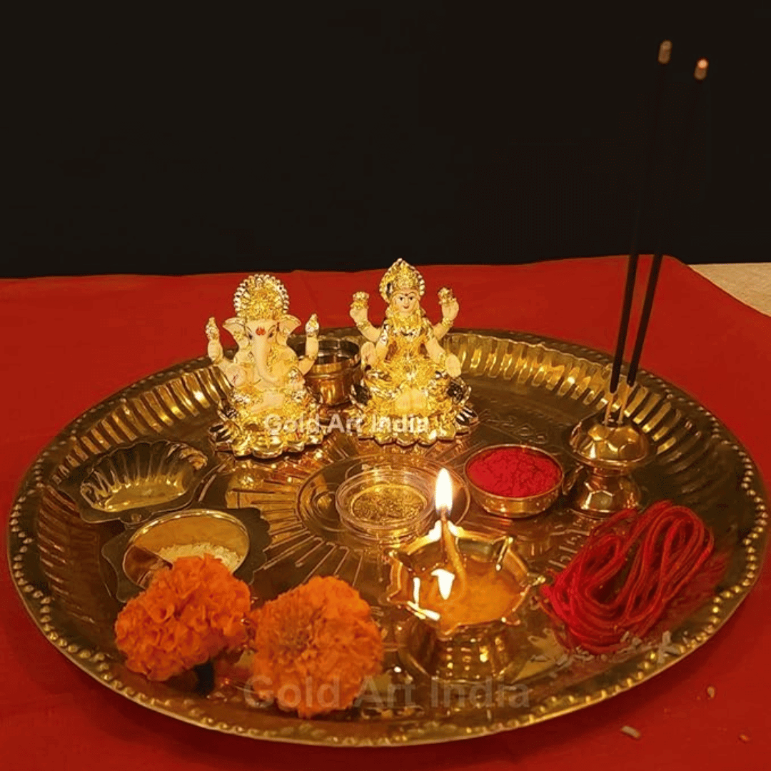 Laxmi Ganesh idol set on a traditional puja thali with incense sticks, flowers, and diya for spiritual blessings.