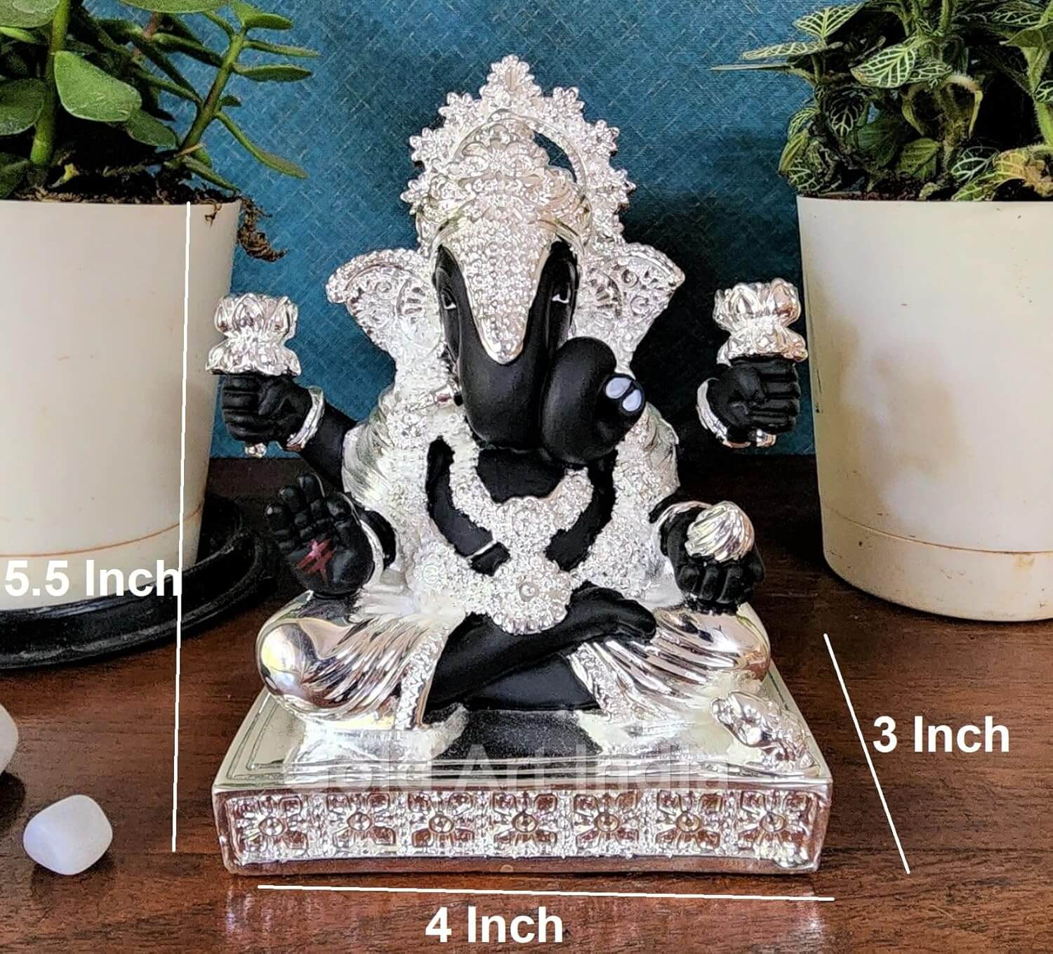 5.5 inch silver plated Ganesha idol next to plant for size reference