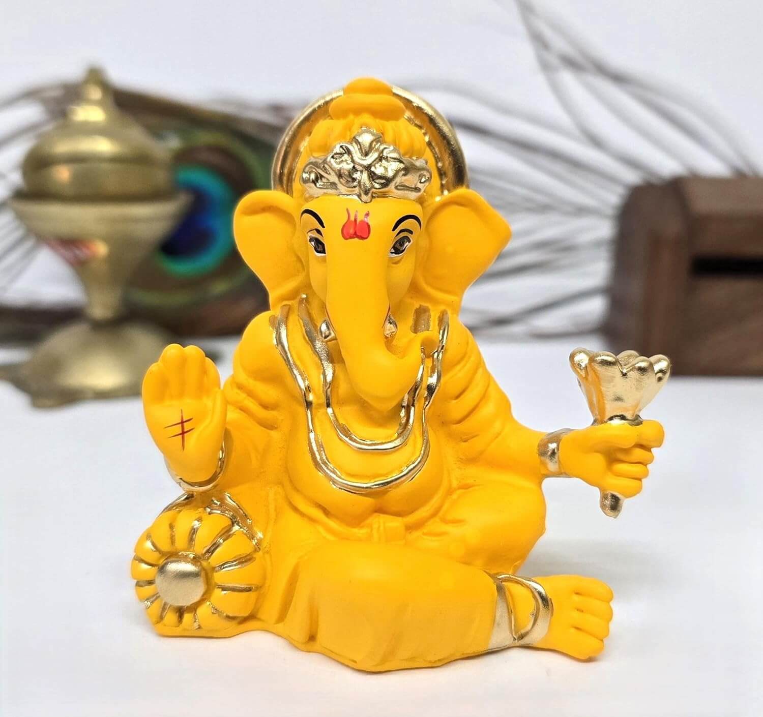 Lord Ganesha idol in vibrant yellow with gold accents, ideal for car dashboards and gifting.