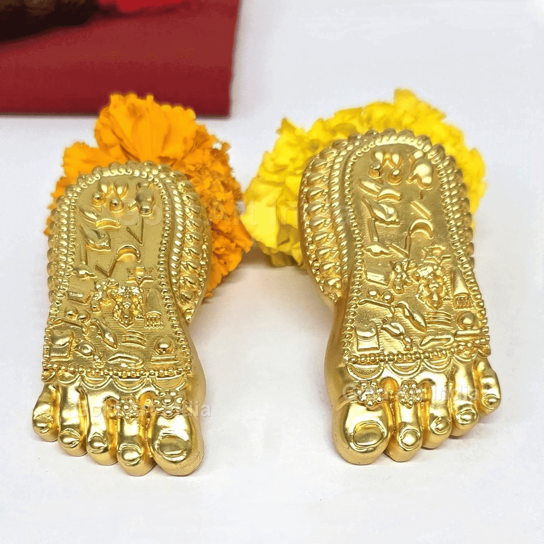 Shri Laxmi Charan Paduka gold plated feet decorative idol with floral accents for home temple decor.