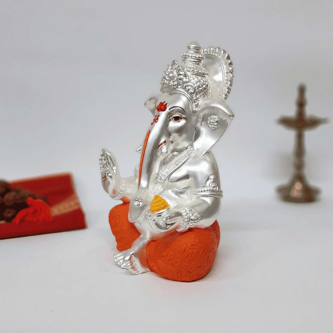 Silver Matte Mukut Ganesh Idol with orange dhoti, perfect for Diwali decor and spiritual spaces.