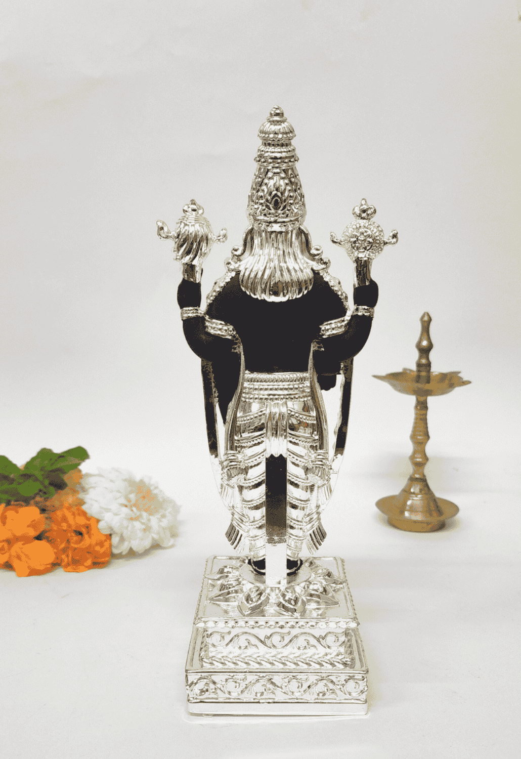 Black and silver Lord Venkateshwara idol, elegantly adorned with intricate silver detailing, standing on an ornate pedestal.
