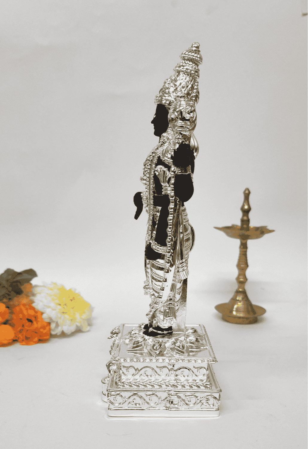 Black and silver Lord Venkateshwara idol, elegantly adorned with intricate silver detailing, standing on an ornate pedestal.