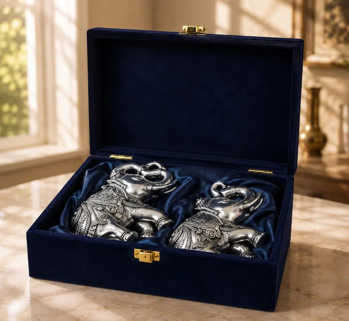Silver plated elephant pair displayed on shelf