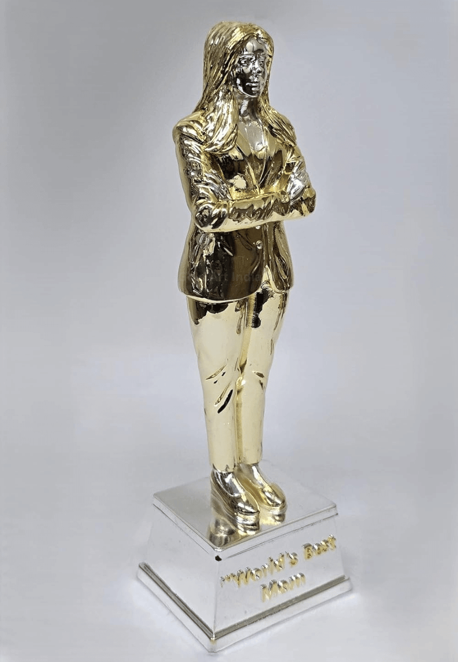 A gold and silver "World's Best Mom" trophy featuring a woman in a suit with arms crossed.