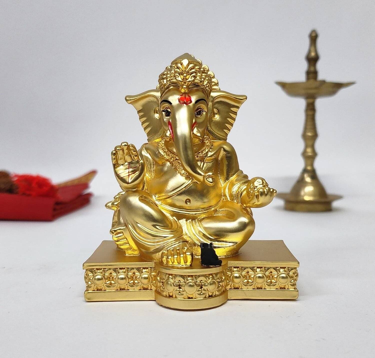 Elegant gold-plated Lord Ganesha idol with intricate detailing, seated on a decorative pedestal, symbolizing wisdom, prosperity, and good fortune. Perfect for home decor, puja rituals, or as a spiritual gift.