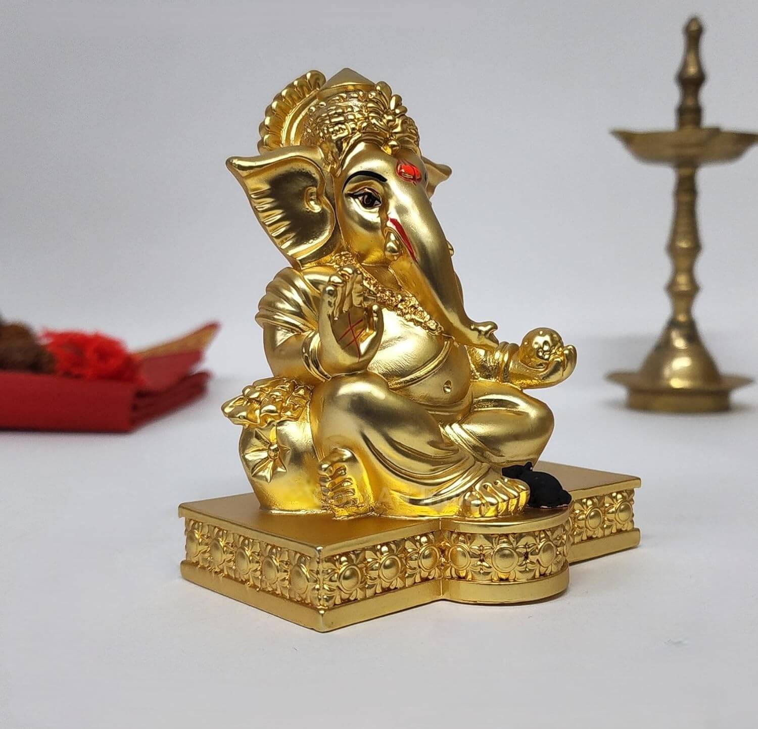 Elegant gold-plated Lord Ganesha idol with intricate detailing, seated on a decorative pedestal, symbolizing wisdom, prosperity, and good fortune. Perfect for home decor, puja rituals, or as a spiritual gift.